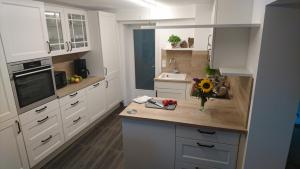 a kitchen with white cabinets and a counter with flowers on it at Teisenbergblick in Gschwend +6 photos