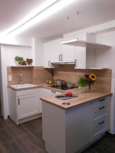 a kitchen with white cabinets and a wooden counter top at Teisenbergblick in Gschwend