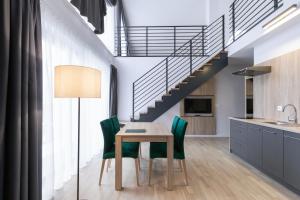 comedor con mesa y sillas verdes en Green Apartments, en Karpacz