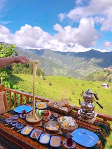 a table with food on it with a view of a mountain at Bungi dağ evleri in Rize