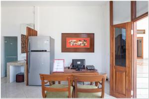 uma cozinha com uma mesa de madeira e um frigorífico em Koolkost near Padang Galak Beach em Denpasar