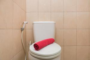 a red towel sitting on a toilet in a bathroom at Elegant Studio Apartment at Margonda Residence 2 By Travelio in Depok +6 photos
