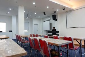 a room with tables and chairs and a person on a piano at Arawa Traveller's Inn Motel in Makassar