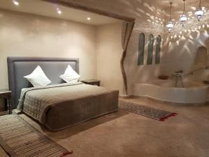 a bedroom with a bed and a bath tub at Palais Villa Talaa Resort in Taroudant