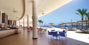 a restaurant with a view of the ocean with tables and chairs at Reef Oasis Blue Bay Resort & Spa in Sharm El Sheikh