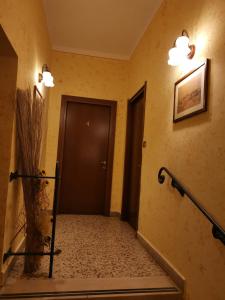un pasillo con una puerta negra y una escalera en Affitta Camere Il Commercio en Gabiano