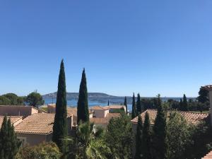 a view of a town with cypress trees at Bouzigues Suite Parentale Étang de Thau in Bouzigues
