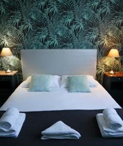 A bed or beds in a room at The Originals Boutique, Hôtel Victoria, Châtelaillon-Plage