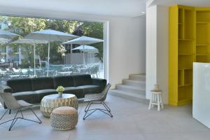 a lobby with a couch and chairs and tables at ibis Styles Golden Sands Roomer Hotel in Golden Sands