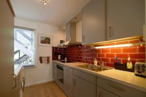 a kitchen with a sink and a red brick wall at Appartement Veerse Kreek in Veere