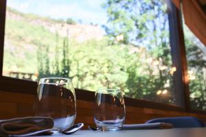 dos copas de vino sentadas en una mesa con una ventana en Hotel Casa Arcas, en Villanova