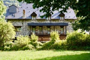 a large stone house with a large roof at Hotel Casa Arcas in Villanova