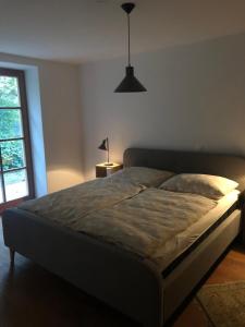 a bed in a bedroom with a lamp and a window at Sonnenhof in Limbach im Burgenland
