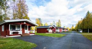 une rangée de cottages sur un chemin de terre dans l'établissement Motelli Rovaniemi, à Rovaniemi