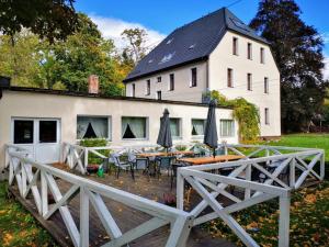 a white house with a table and chairs in front of it at Ośrodek Wypoczynkowy Radosno in Sokołowsko