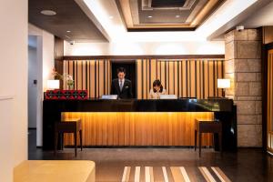 a man and a woman sitting at a bar in a lobby at DogoYaya in Matsuyama