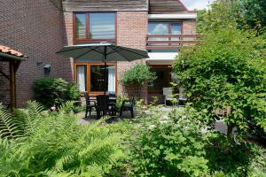 a patio with a table and chairs and an umbrella at Appartement Veerse Kreek in Veere