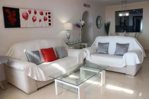 een woonkamer met twee witte banken en een glazen tafel bij Penthouse Patio de doña Julia in Casares