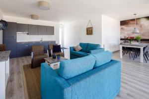 a living room with a blue couch and a kitchen at RCN Vakantiepark de Schotsman Bungalow de Boei in Kamperland