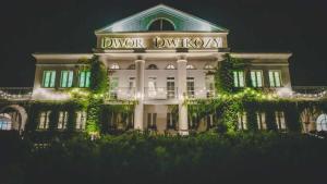 a white building with a sign on it at night at Dwór Dwikozy in Dwikozy