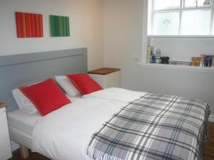 a bed with two red pillows in a bedroom at Nest Apartments in Reykjavík