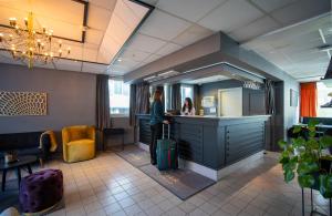 特羅姆瑟的住宿－阿馬利亞入住酒店，一名妇女带着行李站在柜台上,在沙龙