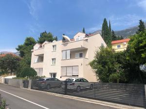 a large white building with a fence on the side of a road at Apartments SVI-MI in Gradac