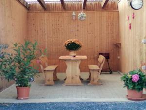a patio with a table and chairs and a clock at Ferienwohnung Preuß in Martinlamitz