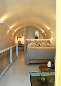 een slaapkamer met een bed in een tunnel bij Esperia Luxury Suites in Astypalaia-stad (Chora)