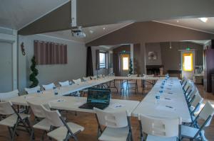 a large room with white tables and chairs and a laptop at CAMPING & SPA CAP SOLEIL in Vias