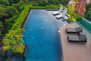 an overhead view of a swimming pool with lounge chairs at The Astra Chaing Mai in Chiang Mai