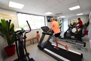 a woman running on a treadmill in a gym at CAMPING & SPA CAP SOLEIL in Vias