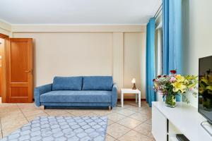 a living room with a blue couch and a tv at Apartments Old Town Więzienna by Renters in Wrocław