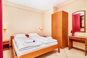 a bedroom with a bed with white sheets and a mirror at Apartments Old Town Więzienna by Renters in Wrocław