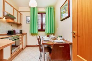 a kitchen with green curtains and a table with chairs at Apartments Old Town Więzienna by Renters in Wrocław
