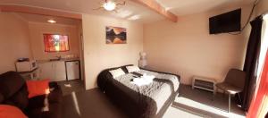 1 dormitorio con 1 cama y TV en Kea Motel en Putaruru
