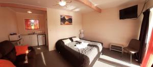 a bedroom with a bed and a television in it at Kea Motel in Putaruru