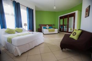 a hotel room with two beds and a couch at Bilene Beach House in Vila Praia Do Bilene