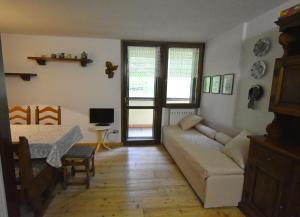 een woonkamer met een bank en een tafel bij Cacciatora Appartamento in Madonna di Campiglio