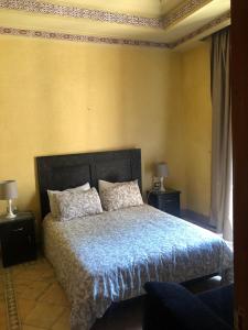 a bedroom with a bed with a blue comforter and two lamps at la palmeraie village Appartement in Marrakech