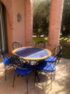 a table and chairs with a blue and yellow at la palmeraie village Appartement in Marrakech
