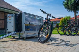 Budzyń的住宿－哈本達酒店，一辆自行车停放在拖车旁,车上配有自行车