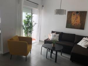 sala de estar con sofá, sillas y mesa en Málaga Apartamentos - Jinetes, 10 en Málaga