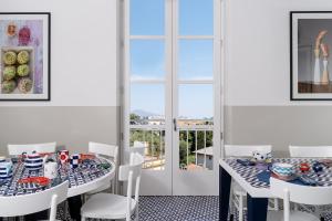 a dining room with two tables and white chairs at Maison Il Conservatorio in Sorrento