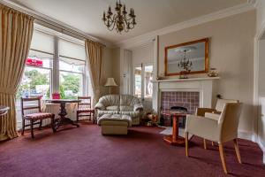 a living room with a chair and a fireplace at Atholl Villa Guest House in Pitlochry