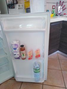 un frigorifero aperto con una bottiglia d'acqua di Villetta sul mare a Villaputzu