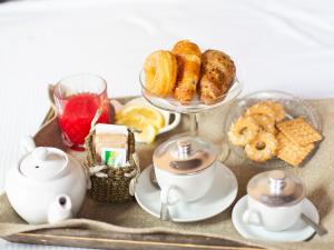 a tray with a tea set with pastries and biscuits at Hotel Adriano in Rome