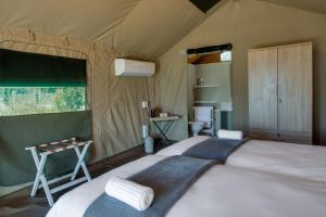a bedroom with a large bed in a tent at Little Mongena Tented Camp in Klipdrift
