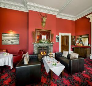 a dining room with red walls and a fireplace at The Greenhill Hotel in Wigton