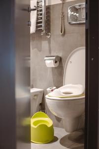 bagno con servizi igienici bianchi e sgabello verde di Hotel Adriano a Roma